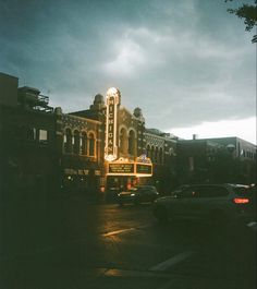 an old theater sign is lit up at night