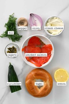 an assortment of foods that include salmon, cream cheese, lemon, and other ingredients