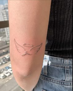 a woman's arm with a tattoo on it that has a bird drawn on it