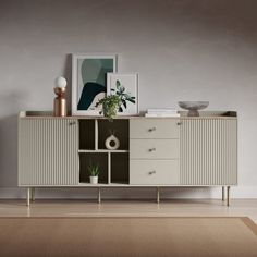 a sideboard with two drawers and a potted plant sitting on top of it