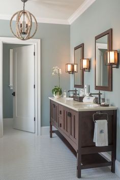 a bathroom with two sinks, mirrors and lights on the wall next to each other