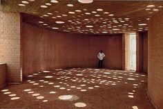 a person standing in an empty room with lots of circles on the wall and ceiling