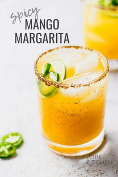 two glasses filled with orange margaritas and garnished with lime