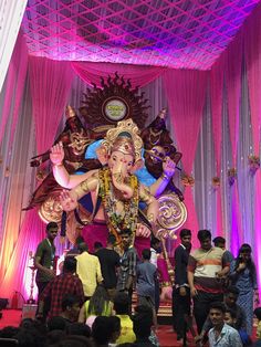 an idol is being displayed in front of a group of people at a function hall