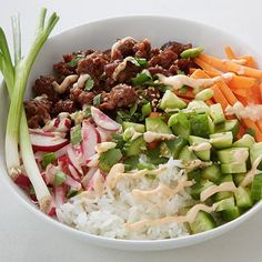 a bowl filled with rice, meat and veggies next to celery