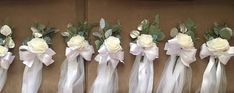 six bouquets of white roses and greenery tied together