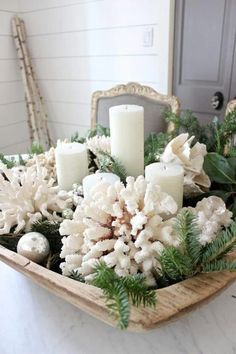 a tray with candles, flowers and greenery in it on a table next to a mirror