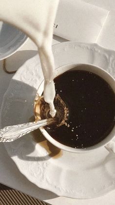 a cup of coffee with milk being poured into it