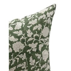 a green pillow with white flowers on it