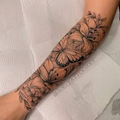 a woman's arm with flowers and butterflies on it