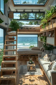 a living room filled with furniture next to an ocean front window and stairs leading up to the second floor