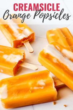 three popsicles with orange and white toppings sitting on top of each other,