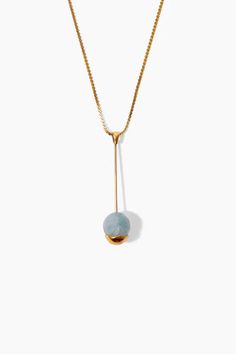 A gold-dipped aquamarine sphere suspends from a slim gold bar giving unexpected balance to this pendant necklace. A serpentine chain completes the look. 18k gold plated sterling silver. 16" - 18" Adjustable. Handmade in Vietnam. Blue Pendant Necklace, Large Pendant Necklace, Aquamarine Pendant, Thread Earrings, Gold Nugget, Blue Pendant, Pink Necklace, Diamond Star, White Necklace