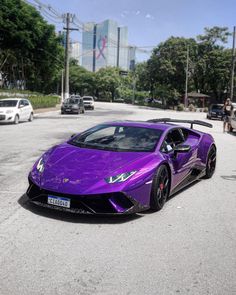 a purple sports car parked in the middle of a street