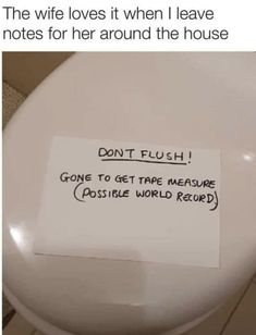 a white toilet with a note attached to it