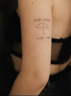 a woman with a tattoo on her arm that says right place right time and an umbrella