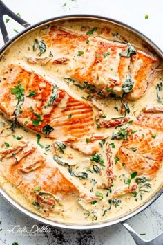 a pan filled with chicken covered in cheese and herbs on top of a white counter