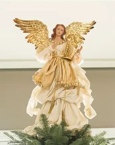 an angel statue sitting on top of a plant