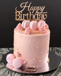 a birthday cake with pink frosting and flowers