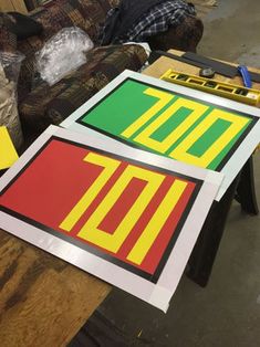 two signs sitting on top of a table next to a couch in a living room