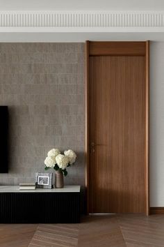 a living room with a flat screen tv on the wall next to a wooden door