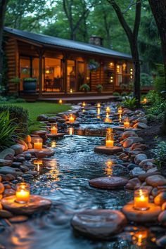 candles are lit on the rocks in front of a stream that runs through a house