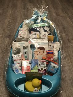 a blue boat filled with lots of items on top of a wooden floor next to a bag