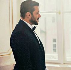 a man in a tuxedo looks out the window at another man wearing a bow tie