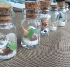 small glass bottles filled with sand and shells