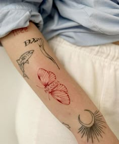 a woman's arm with tattoos on it and a butterfly in the middle of her arm