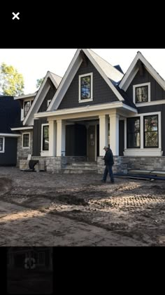 a man walking in front of a house under construction