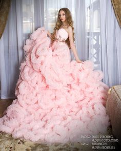 a woman in a pink dress is posing for the camera