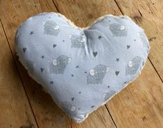 a heart shaped pillow sitting on top of a wooden floor covered in stars and elephants