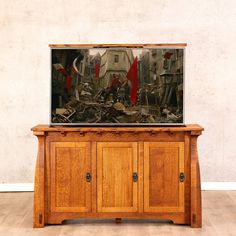 a fish tank sitting on top of a wooden cabinet in front of a white wall