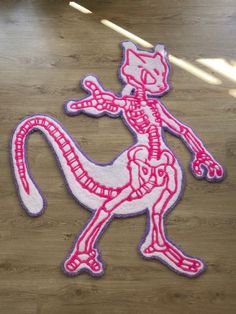 a pink and white lizard rug sitting on top of a wooden floor