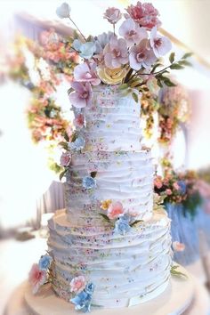 a white wedding cake with pink and blue flowers