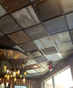 the ceiling is covered with metal roofing and lit candles are hanging from it's sides