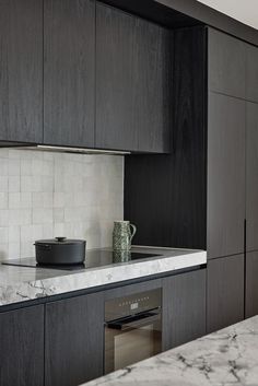 a kitchen with marble counter tops and black cabinets