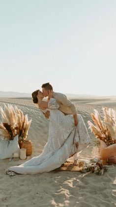 a bride and groom kissing in the desert