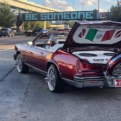 an old car with its hood open and the italian flag painted on it's trunk