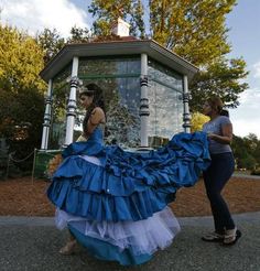 two women in blue dresses standing next to each other