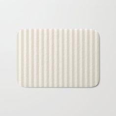 a white and beige striped bath mat on a white background with no one in it