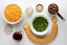 an assortment of cheeses, crackers, and other foods are arranged in the shape of a smiley face