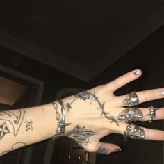 a person with many tattoos on their arm and hand is holding something in the air