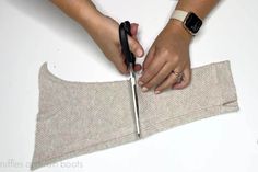 a person cutting fabric with scissors on top of a white table next to an apple watch