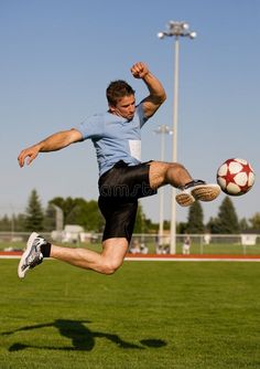 a man kicking a soccer ball in the air on a field royalty images and stock photos