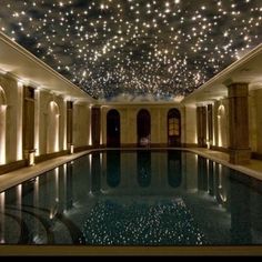 an indoor swimming pool with stars on the ceiling and lights in the ceiling above it