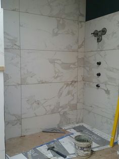 a bathroom being remodeled with white marble walls