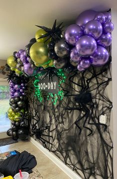 the balloon wall is decorated with purple and green balloons