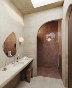 a bathroom with two sinks and a skylight in it's center area, along with a large mirror on the wall